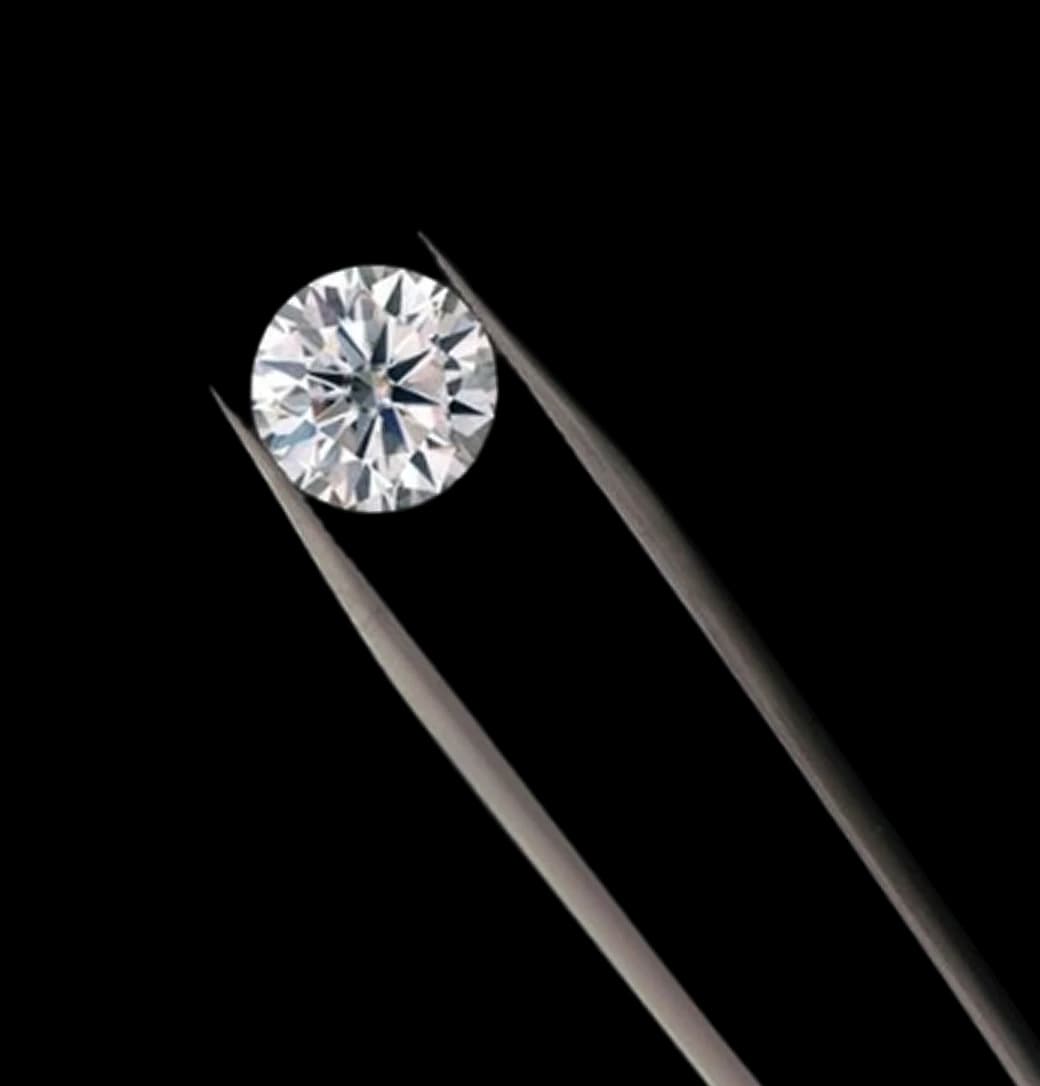 Round brilliant diamond held by tweezers